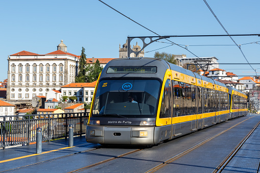 Porto, Portugal - September 22, 2021: Modern light rail Metro do Porto tram public transport transit transportation traffic on Ponte Dom Luis I bridge in Porto, Portugal.