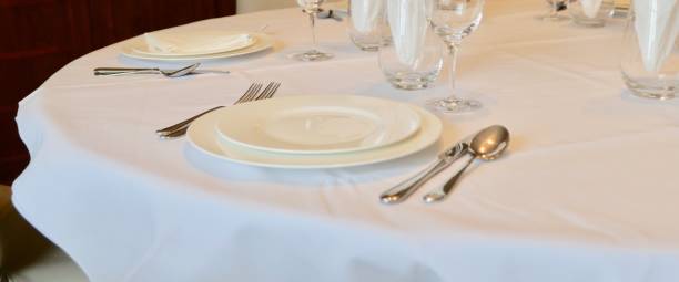 istock Cutlery and crockery on white table cloth 1369008132