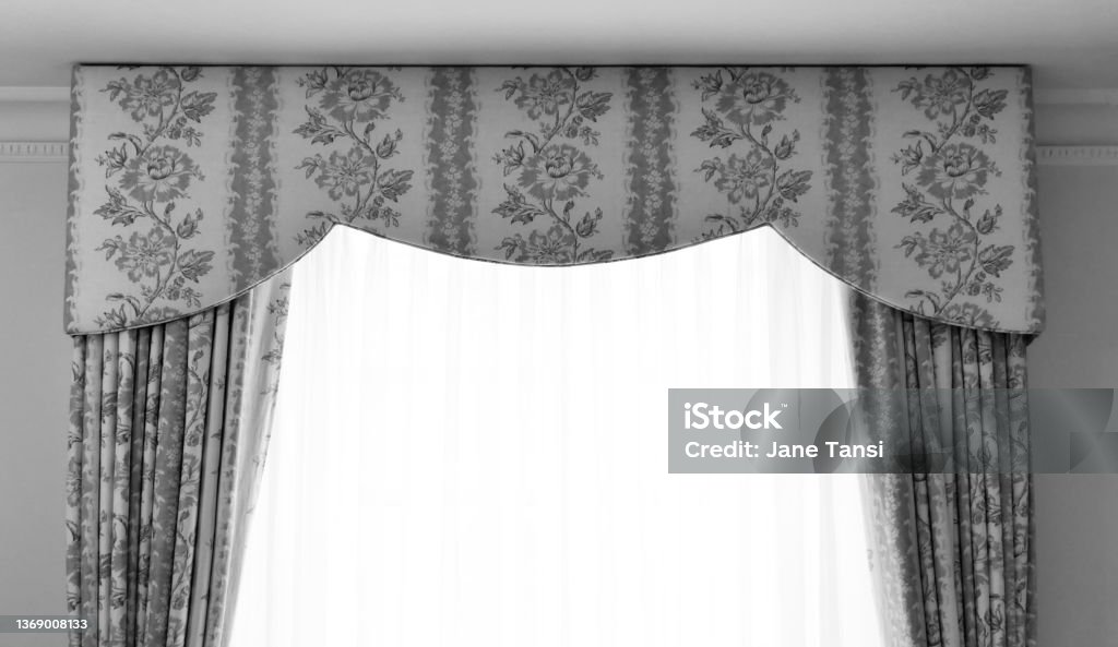 Black and white image of pelmet and brocade curtains with voile curtains Black and white image of pelmet and brocade curtains with voile curtains. Copy space. Backgrounds Stock Photo