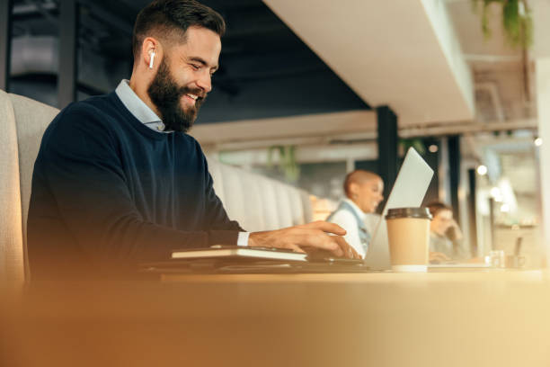 alegre empresário trabalhando em seu laptop - using computer audio - fotografias e filmes do acervo