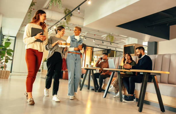 istock Businesswomen walking through a modern co-working space 1369010211