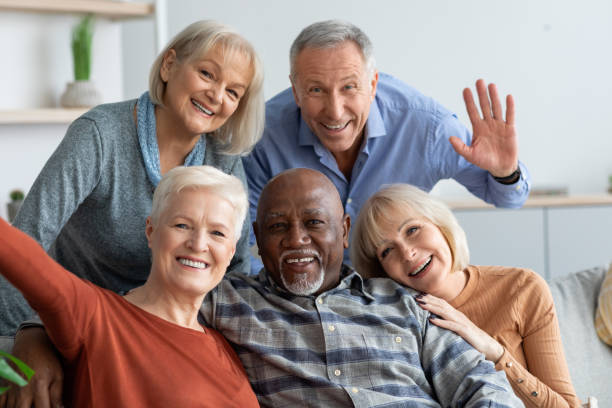 istock Happy elderly people taking selfie together, home interior 1369011906