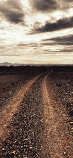 istock vertical desert mountain adventure trail dark empty silhouette evening dusk horizon dirt road moody sepia landscape scene 1369016817