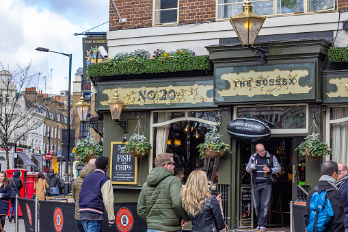 The Sussex Pub in Covent Garden, London, with many people walking outside.