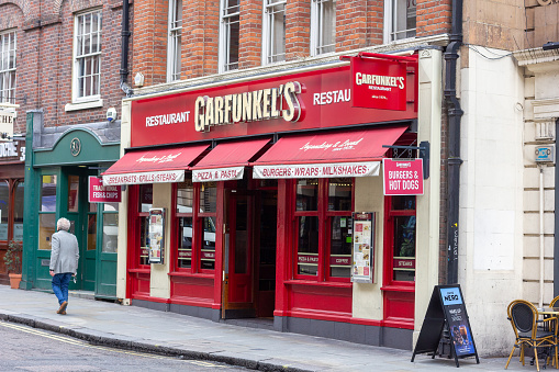 Garfunkel's Restaurant in City of Westminster, London, with a person walking past. The brand opened in 1979 but many branches closed during the pandemic.