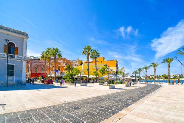 cafés et boutiques en plein air colorés sur le trottoir du front de mer le long de la promenade du front de mer de brindisi en italie, dans la région des pouilles. - brindisi photos et images de collection