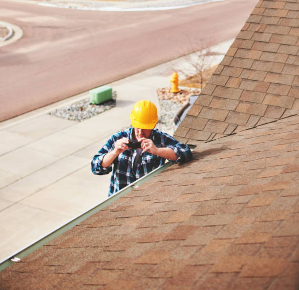 istock Insurance agent or roofer on roof assessing damage to a roof 1369018954