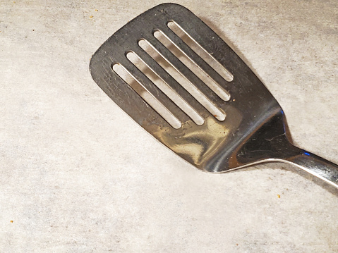 Baking sheet with parchment paper and a metal spatula closeup