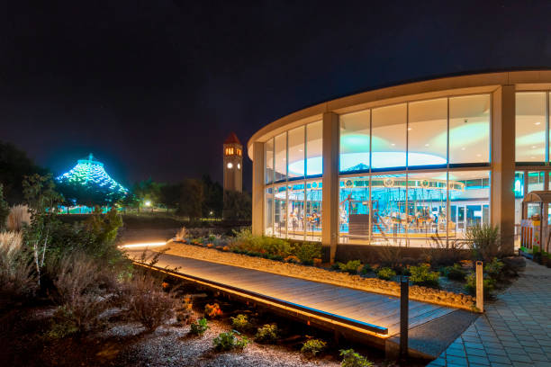 The Looff carousel, Great Northern Clock Tower and Pavilion are all illuminated at night on the Spokane River in Riverfront Park, Spokane Washington. The Looff carousel, Great Northern Clock Tower and Pavilion are all illuminated at night on the Spokane River in Riverfront Park, Spokane Washington. spokane river stock pictures, royalty-free photos & images