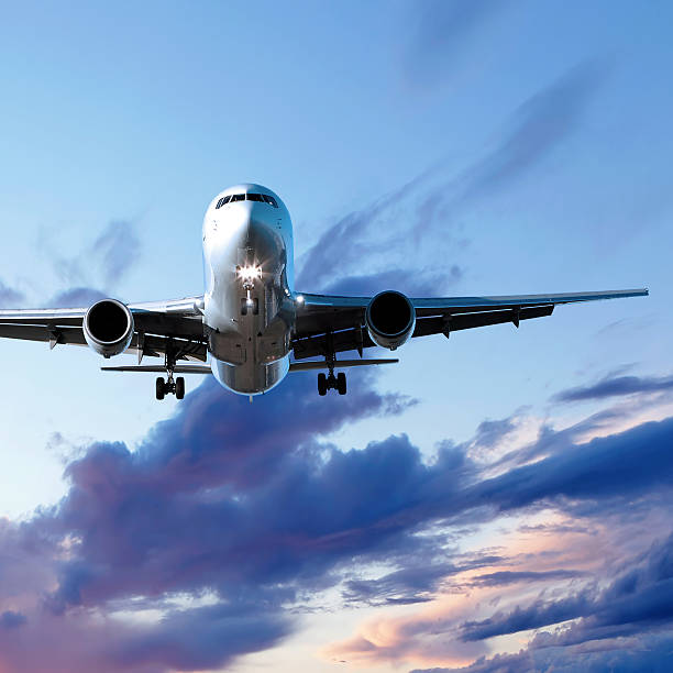 istock jet airplane landing at sunset 136902369