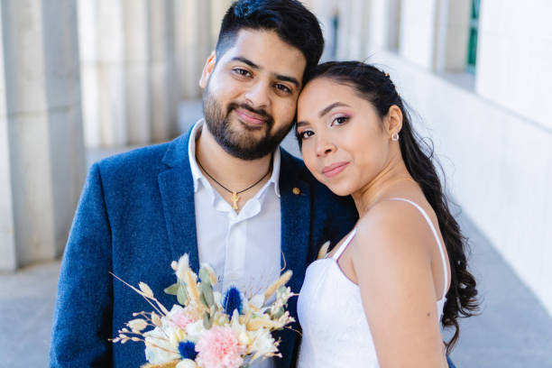 istock latin bride and groom looking at camera, smiling happily 1369025251