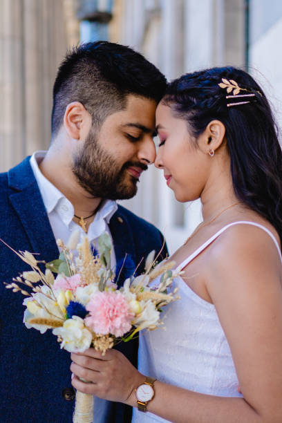 latynoska para młoda twarzą w twarz z zamkniętymi oczami, bukiet ślubny, zdjęcie pionowe - weddings brown hair cheerful affectionate zdjęcia i obrazy z banku zdjęć