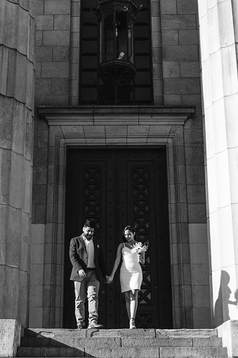 latin bride and groom walking down the stairs just married, black and white photo, artwork
