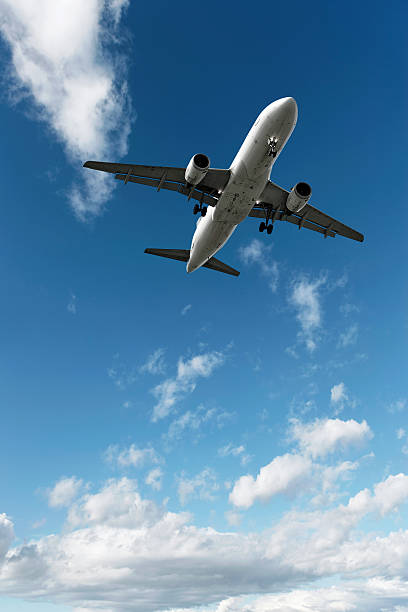 jet airplane landing in bright sky stock photo