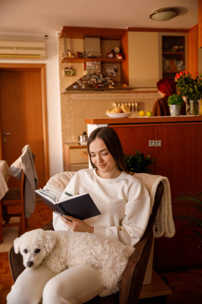 istock Cuddling with a dog and writing memories in a diary 1369027036