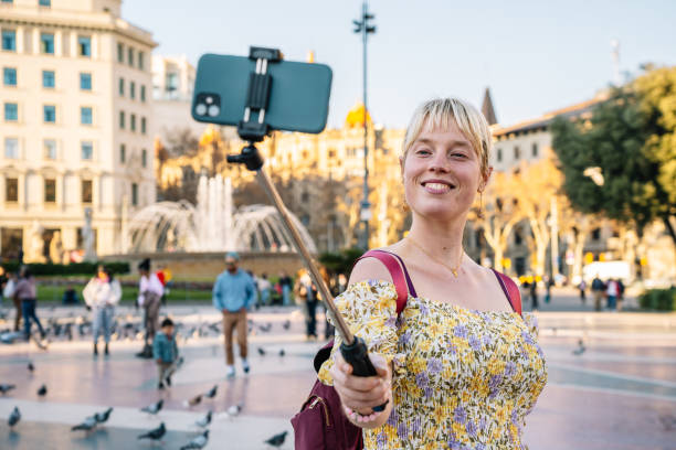 Smiling woman taking selfie on smartphone in park