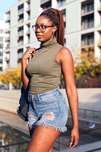 vertical photo of a young black girl with a backpack walking through the city, concept of youth and urban lifestyle, copy space for text
