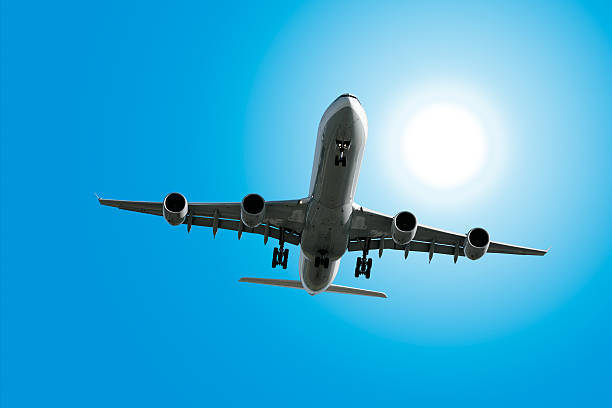 istock XL jet airplane landing in sunny sky 136902907