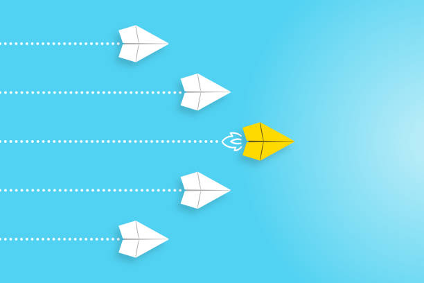 istock Leadership concepts with yellow paper airplane leading among white 1369033064