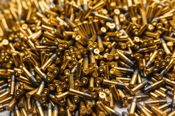istock Heap of black and golden small-caliber bullets on table 1369033890
