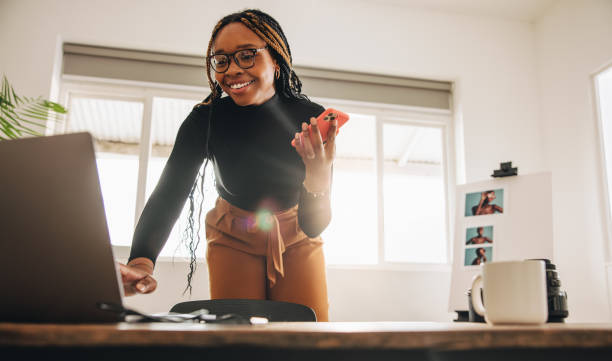 istock Creative young woman taking a phone call in her home office 1369035063
