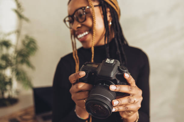 istock Woman holding a dslr camera in her workspace 1369037290