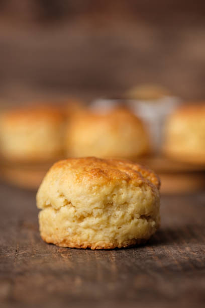 group of scones on wood plate with jam on table
