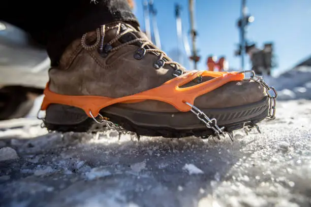 Profile View Close-up of Crampon on Hiking Boot.