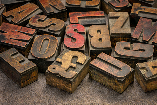 alphabet abstract in vintage letterpress wood type printing blocks (mirror image) against handmade bark paper