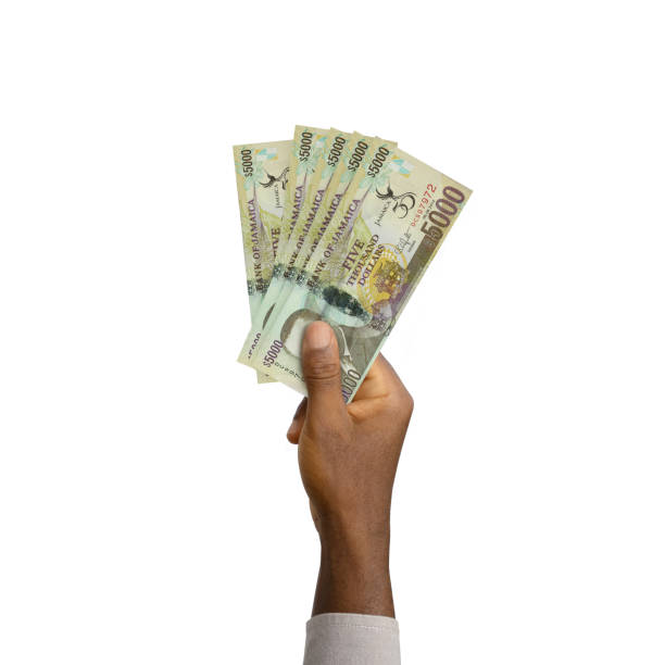 istock Black Hand holding 3D rendered Jamaican dollar notes 1369041500