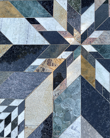 Geometric stone tile pattern of inlayed granite and marble