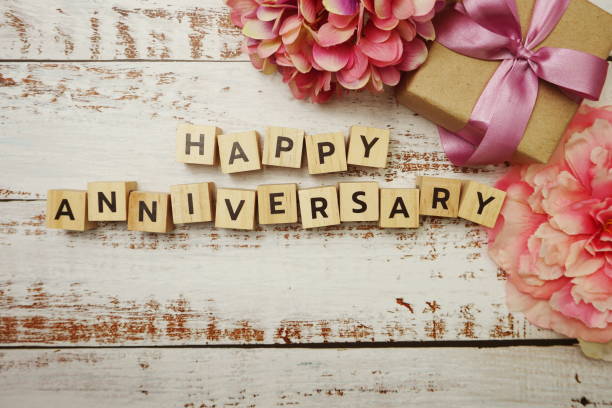 istock Happy Anniversary alphabet letter with gift box on wooden background 1369043630