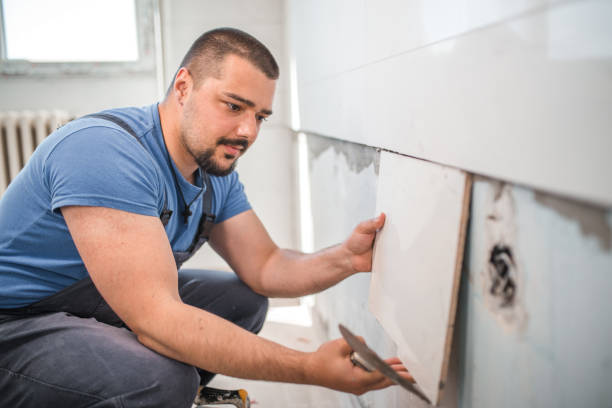 istock Focused worker gluing ceramic tiles 1369049386