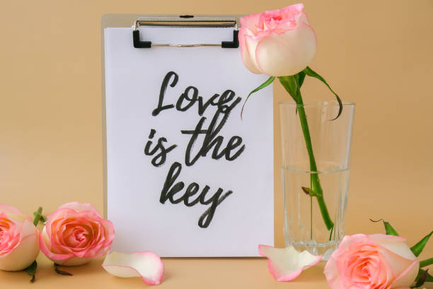 LOVE IS THE KEY text on greeting card paper note. Delicate pink roses on beige background. Minimal trendy composition. Romantic pastel pink rose flowers. Neutral earth tones. Preparation for Valentines day Modern stylish el amor es el texto clave en la nota de papel de la tarjeta de felicitación. delicadas rosas rosas sobre fondo beige. composición mínima de moda. románticas flores de rosa rosa pastel. tonos tierra neutros. preparación para el día de san valentín