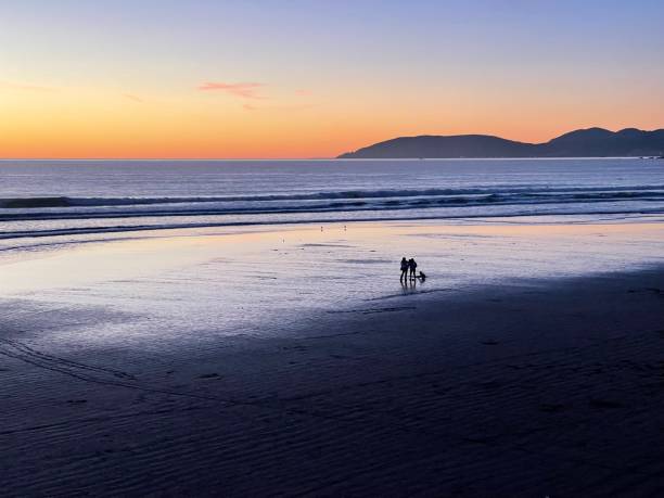 istock People relaxing on the beach at sunset 1369059448