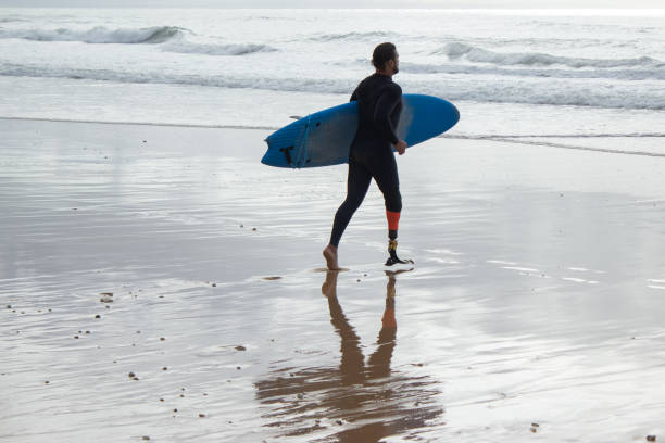 istock Back view of dark-haired man training on beach alone 1369060293