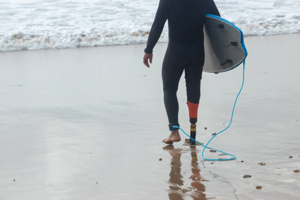 istock Back view of sporty man walking on beach 1369060333