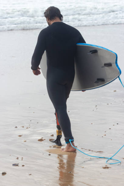 istock Back view of man with wavy hair walking on beach 1369060356