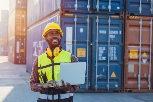 istock Black African staff workerworking in cargo shipping logistic port with laptop computer. 1369061511
