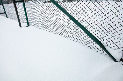 Wire mesh fence covered with snow