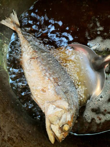 istock Frying Mackerel Fish in cooking pan - food preparation. 1369066162