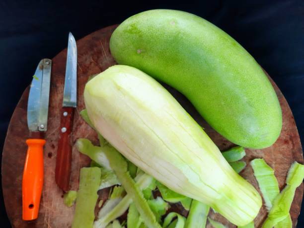 istock Peeling Gourd vegetable on cutting board - food preparation. 1369066390