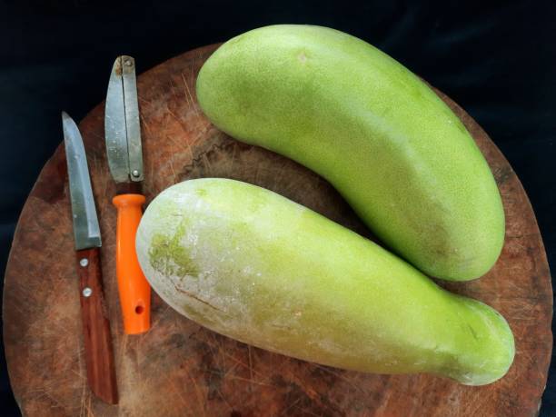 istock Peeling Gourd vegetable on cutting board - food preparation. 1369066396