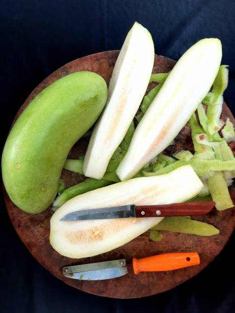istock Peeling Gourd vegetable on cutting board - food preparation. 1369066397