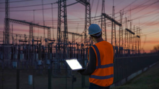 istock Confident male engineer using a laptop in front of electric power station 1369067445