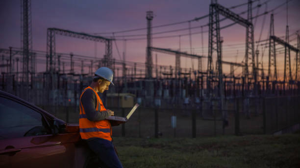 quality control on power station at dusk - computer construction using laptop construction site imagens e fotografias de stock