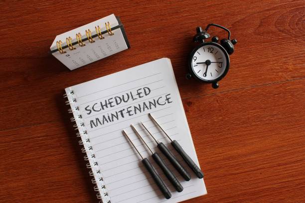 kalender, wecker, schraubendreher und buch mit text scheduled maintenance. - preventative maintenance stock-fotos und bilder