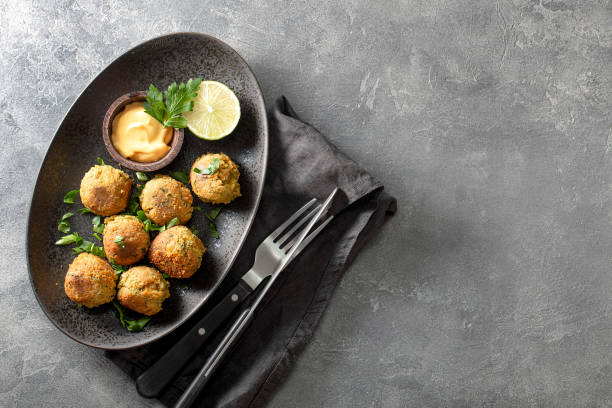 istock Chickpea falafel with sauce on black plate and grey background top view, copy space for text 1369070691