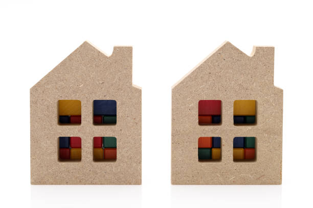 small toy house and wooden building blocks on white background