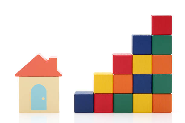 small toy house and wooden colorful building blocks on white background